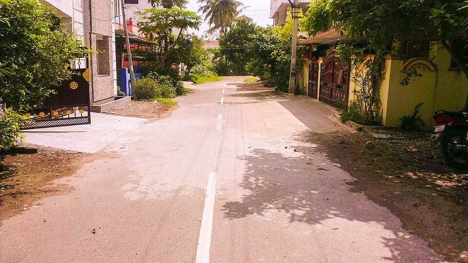 Quiet residential street with houses and trees in Thiru Kumaran Nagar Extension