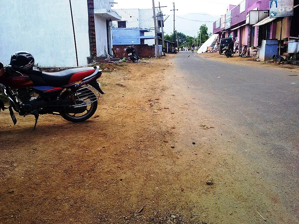 Road with a parked motorbike and roadside shops in Veeranam, Salem